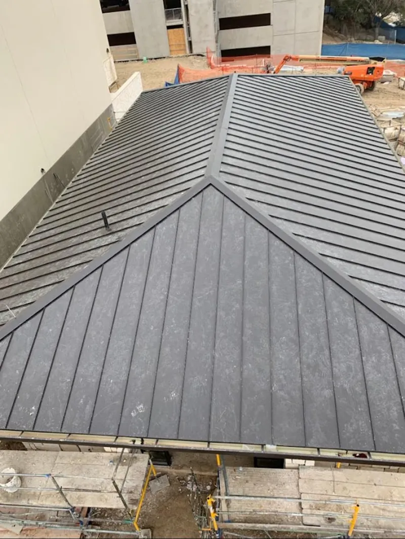 Commercial metal roof construction with crane equipment in Tonganoxie